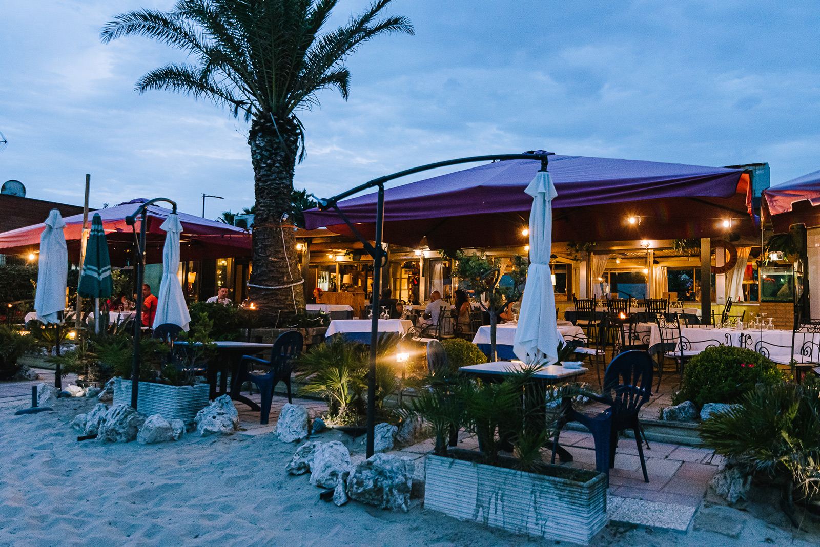 La terrazza de Lo Scoglio sulla spiaggia, la sera